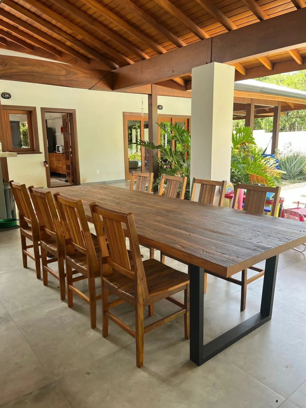 Mesa de jantar de madeira de demolição numa varanda